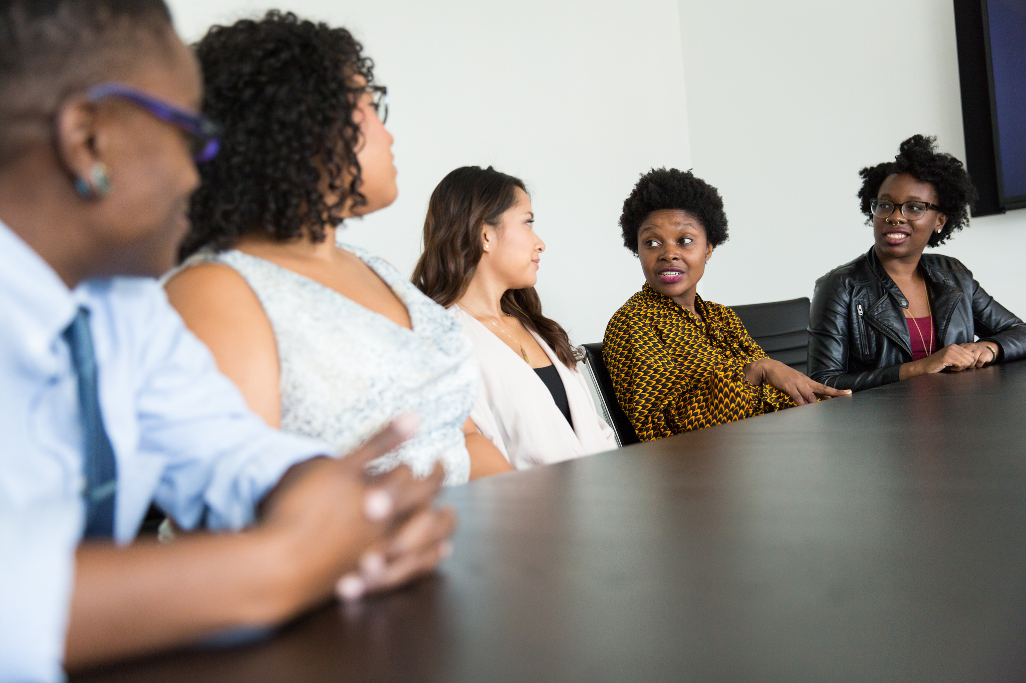 Stock Photo of Several Women of Color Sitting at a Conference Table